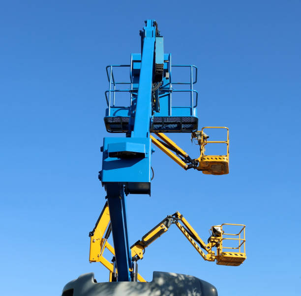 istock Three aerial working platforms  of cherry picker against blue sky. 1421606214