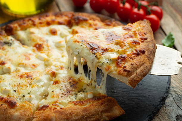 une tranche de pizza italienne chaude avec du fromage étirable. pizza quatre fromages au basilic. - salami sausage portion decoration photos et images de collection