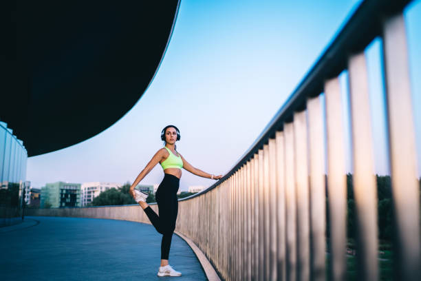 istock Slim sportswoman stretching leg near railing during workout 1421612037