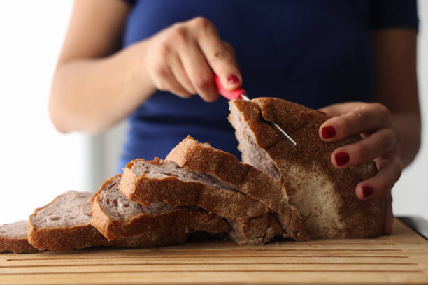 istock A woman cutting bread on cutting board 1421618074