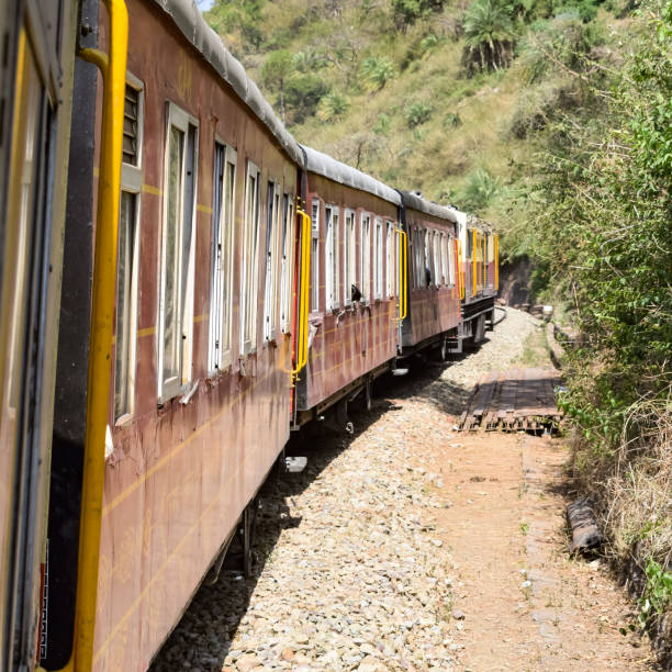 istock Toy Train moving on mountain slopes, beautiful view, one side mountain, one side valley moving on railway to the hill, among green natural forest. Toy train from Kalka to Shimla in India, Indian Train 1421618212