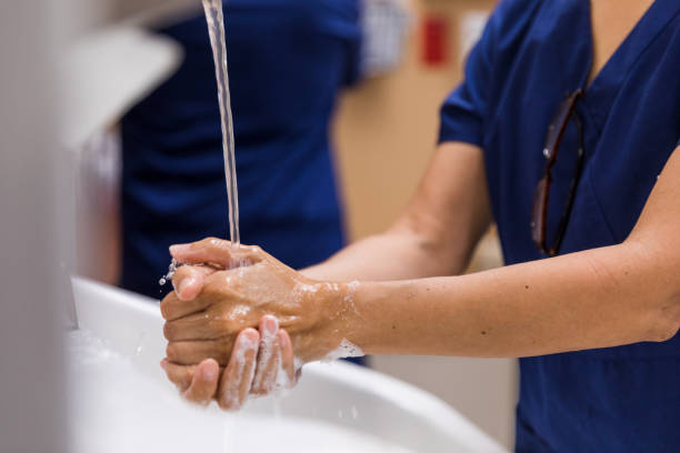 石鹸と水で手を洗う医療従事者をクローズアップ - 徹底的に洗う ストックフォトと画像
