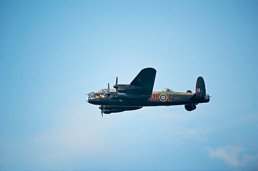 Avro Lancaster heavy bomber, Bournemouth, England. This four-engine bomber aircraft in flight over open sea with cumulus cloud formation in blue sky was the mainstay of bomber command in WW2