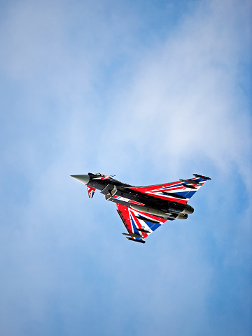 Eurofighter Typhoon, Bournemouth, England. The Eurofighter Typhoon is a European built multinational, twin-engine, canard delta wing, multirole fighter, seen here in flight over open sea with cumulus cloud formation in blue sky