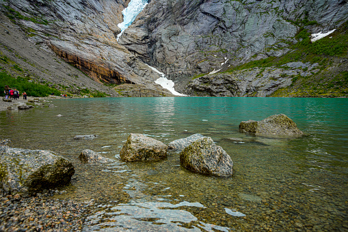 Waterfall and meltwater lake in the valley below Briksdal Glacier in Norway.