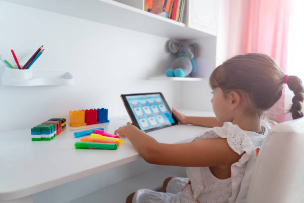 istock Cute Girl sitting at home and studying over internet 1421621875