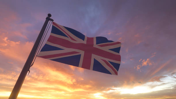 UK Flag on Flagpole by Evening Sunset Sky stock photo