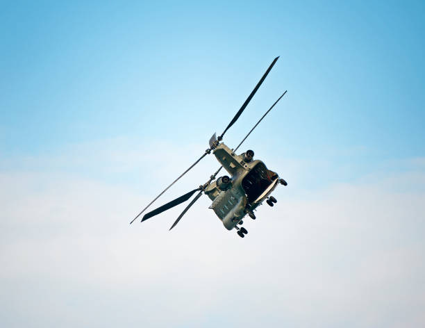 曇った青い空に浮かぶ船尾からのチヌーク重揚力ヘリコプター - military airplane helicopter military boeing vertol chinook ストックフォトと画像