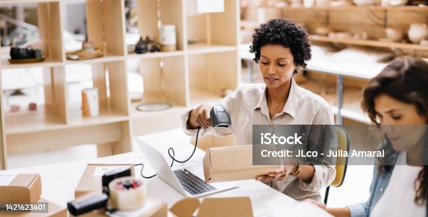 Online Store Owner Scanning The Barcode Of A Package Box In A Warehouse Stock Photo - Download Image Now