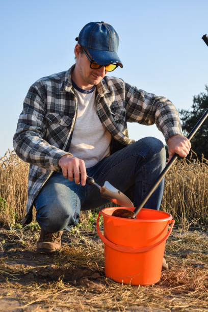 istock Male agronomy specialist performing soil sampling at sunrise 1421623632