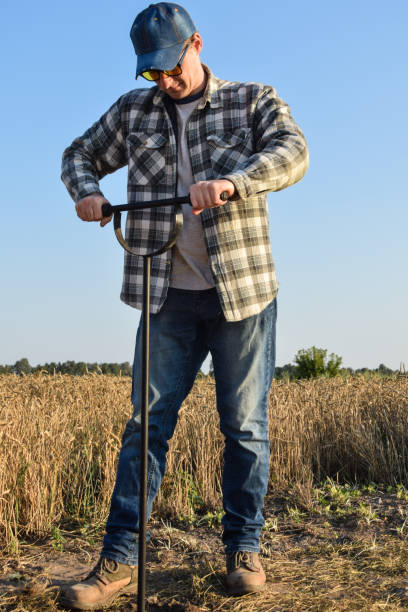 Male agronomy specialist performing soil sampling at sunrise Male agronomist taking sample with soil probe sampler at agricultural field at sunrise. Farmer using drilling tool for soil sampling at morning outdoors. Environment research, soil certification soil sample stock pictures, royalty-free photos & images