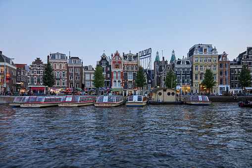 Cityscape of The River Amstel with canal houses at dusk, Amsterdam, The Netherlands