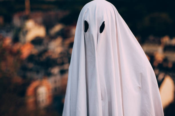 istock Ghost standing against evening city during Halloween 1421625968