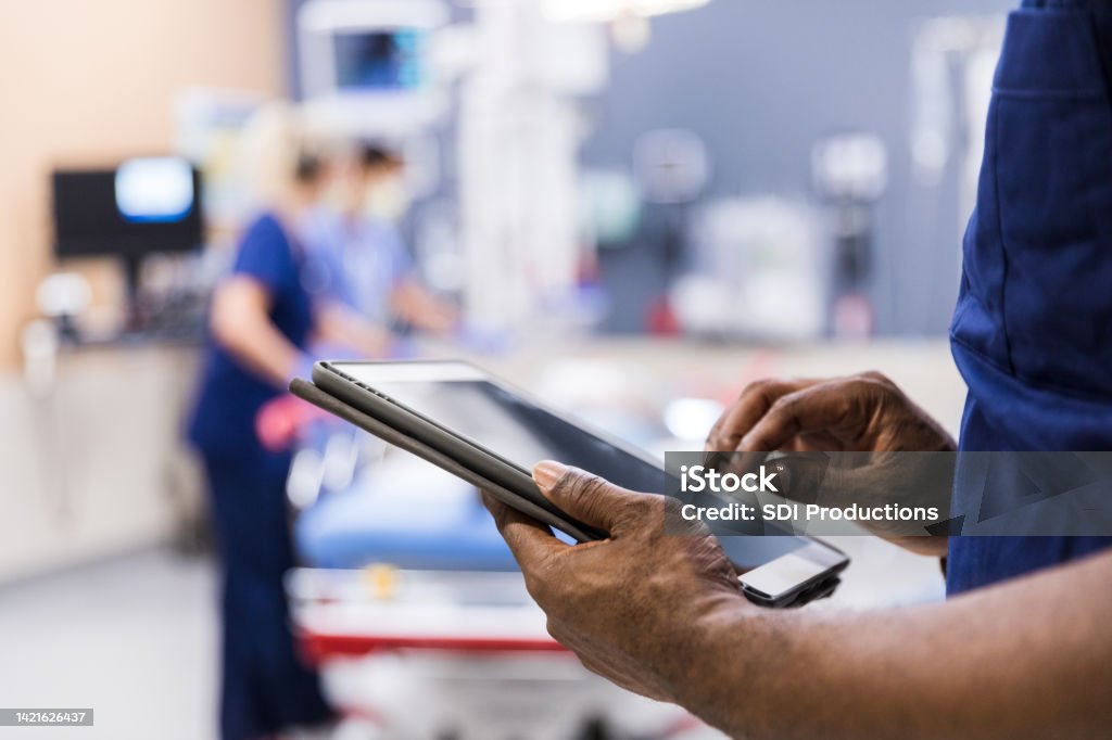 Unrecognizeable person using digital tablet The unrecognizeable medical staff uses digital tablet to review medical chart. Healthcare And Medicine Stock Photo