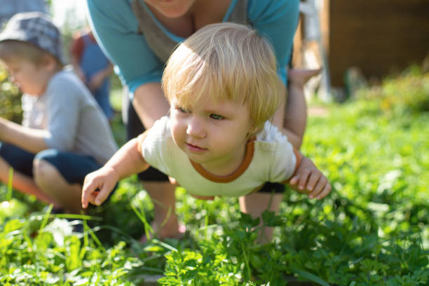 Adorable 4 year old girl, full of joy and happy smiles, being playful and a little wild, laying on the grass in the spring or summer. nature, outdoor portrait