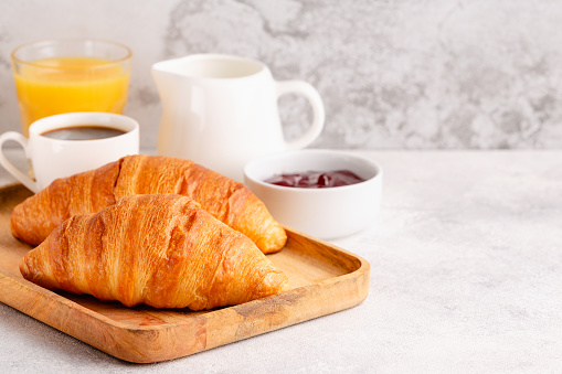 Hot coffee, croissants on a light background, selective focus. Breakfast concept
