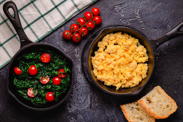 istock Cooked omelet and spinach with tomatoes in pans 1421631975