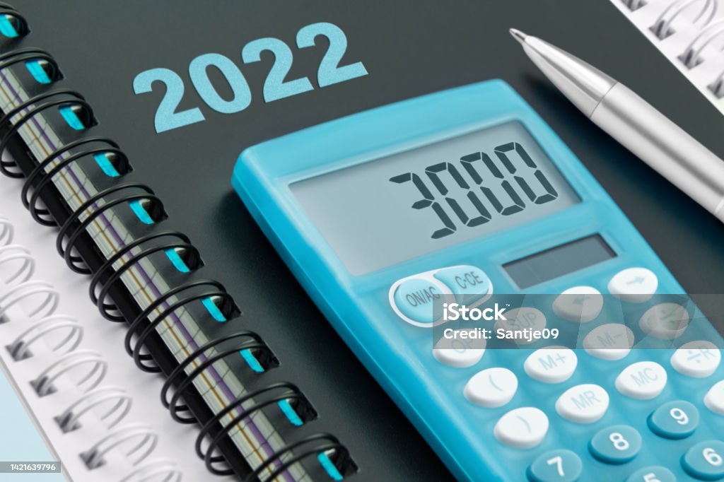 Calendar 2022 and blue calculator with 3000 Euro Bonus Pay Stock Photo
