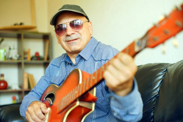 A man playing guitar in his living room.
