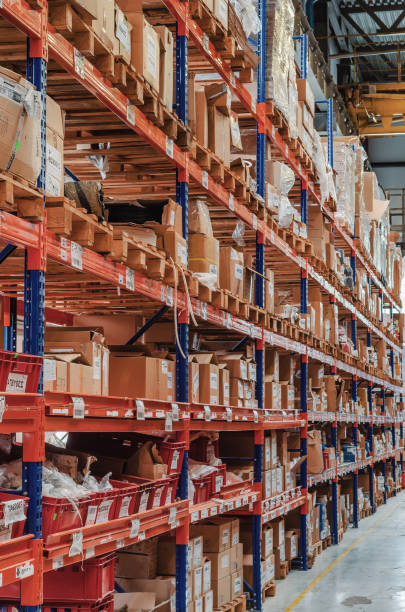 istock Industrial distribution, composition. Storage with high shelves, cargo boxes on racks. Rows of shelves with boxes at the factory. 1421644532