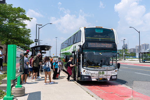 Mississauga, Ontario, Canada - July 25 2021 : People lining up to board GO Bus at Square One Bus Transit Terminal.