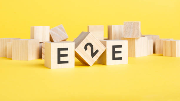istock wooden blocks with word e2e on yellow background. end to end concept 1421650274