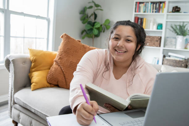 Hispanic college student using her laptop to study. Hispanic college student researching for a school paper. types of loans stock pictures, royalty-free photos & images
