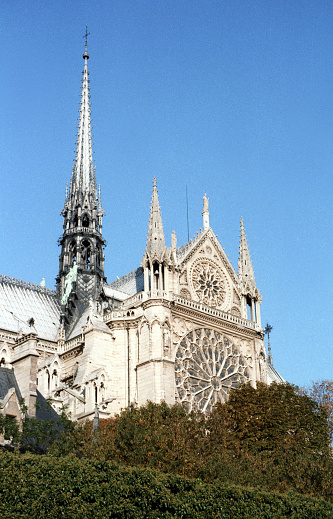 Paris, France - 1983: A vintage 1980's Fujifilm negative film scan close up of Notre Dame de Paris cathedral on a clear blue sky day.