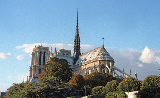 Paris, France - 1983: A vintage 1980's Fujifilm negative film scan of Notre Dame de Paris cathedral on a clear blue sky day.