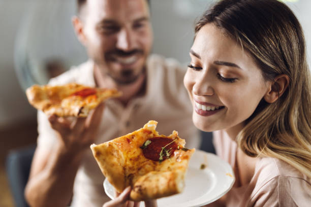istock Young couple  while eating pizza at home 1421655473