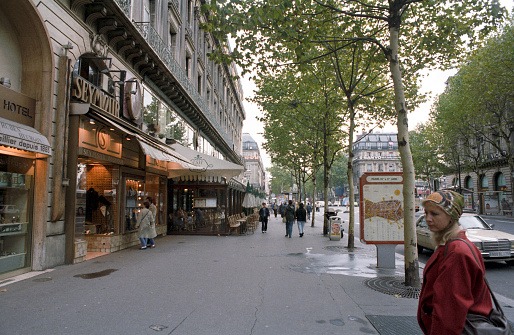 Paris, France - 1983: A vintage 1980's Fujifilm negative film scan of the sidewalks down the  down the  avenue des Champs Elysees with crowds of tourists.