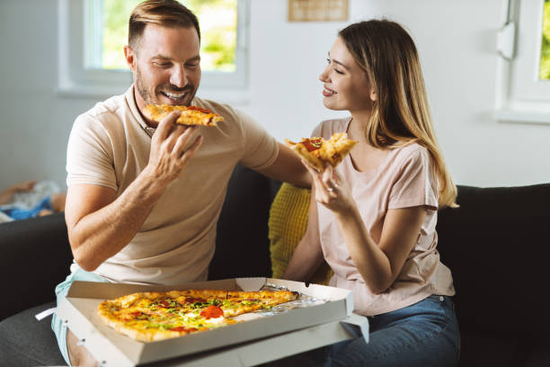 istock Young couple  while eating pizza at home 1421658069