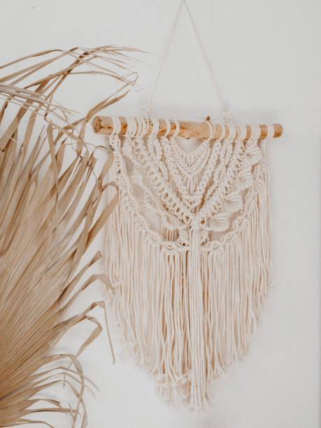 istock Cotton macrame wall decoration hanging on the wall and part dry palm leaf 1421658995