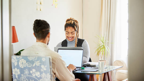 istock Smiling coworkers working on laptops in their start up's home office 1421659734