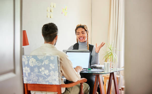istock Smiling coworkers talking while working in their start up's home office 1421659739