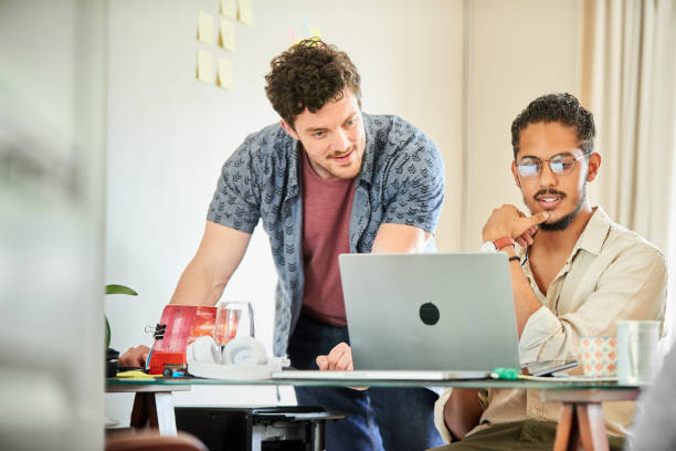 istock Young colleagues working on a laptop in their start up's home office 1421660126