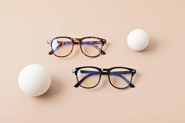 istock Stylish eyeglasses over pastel background. Optical store, glasses selection, eye test, vision examination at optician, fashion accessories concept. Top view, flat lay 1421660277