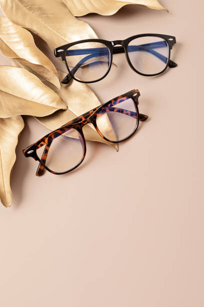 istock Stylish eyeglasses over pastel background. Optical store, glasses selection, eye test, vision examination at optician, fashion accessories concept. Top view, flat lay 1421660281