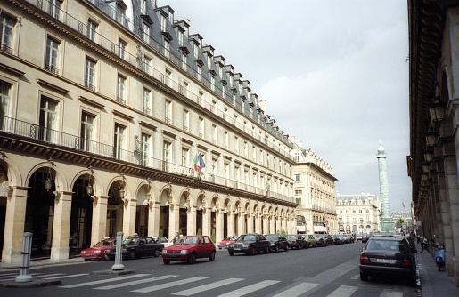 Paris, France - 1983: A vintage 1980's Fujifilm negative film scan of streets and buildings in central Paris, France with cars and pedestrians traveling.