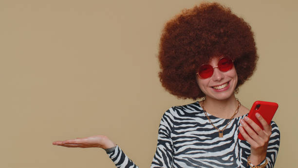 istock Girl using smartphone show thumbs up like, positive feedback, pointing empty place, advertising area 1421661636