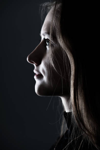 istock Low light side view of woman studio portrait 1421661860