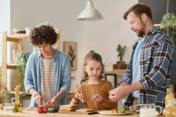 istock Family preparing dinner together at home 1421662271