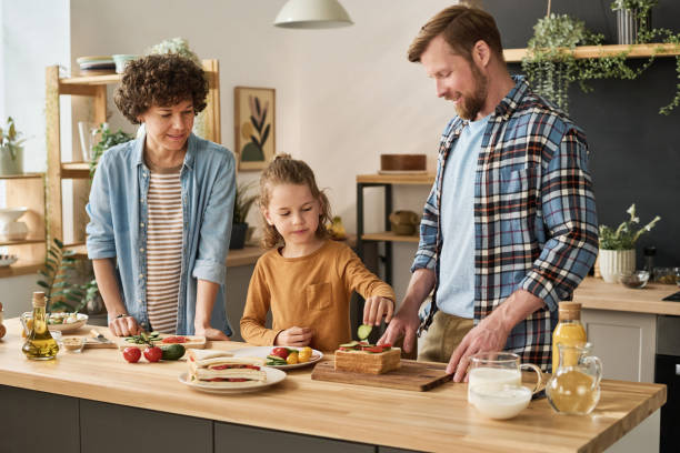 istock Little boy preparing sandwiches with parents 1421662291