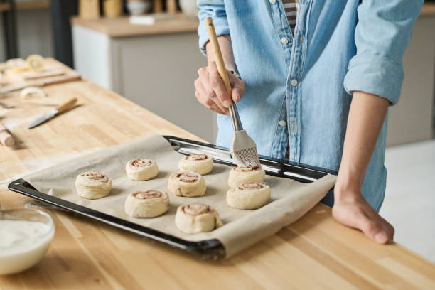 Woman baking buns with cinnamon