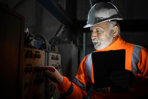 Electrical engineer in the dark checking installations to detect and fix the problem with electricity.