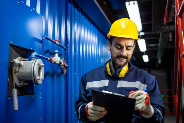 istock Factory supervisor or foreperson walking through industrial plant with checklist and doing quality control. 1421664345