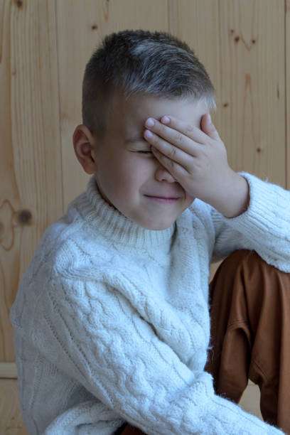 istock the future schoolboy covered his face with his hand in embarrassment 1421664576