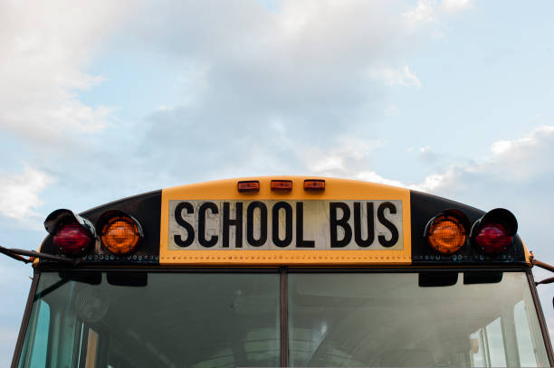 istock Front top view of a yellow school bus on a sky with clouds 1421665332
