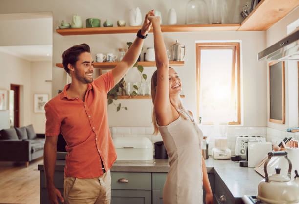 istock Happy, dancing and loving couple bonding and having fun while spending time together at home. Energetic, fun and active couple sharing a dance and romantic moment while enjoying their anniversary 1421665908