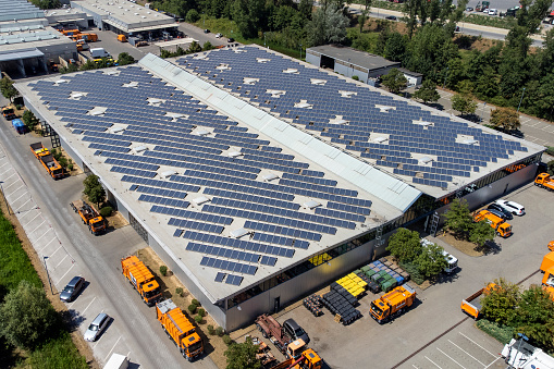 Large industrial building, solar panels and trucks - aerial view